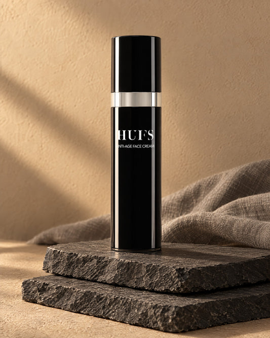 HUFS Anti Age Face Cream 50 ml im schwarzen Airless-Spender auf gestapelten Schieferplatten im Abendlicht