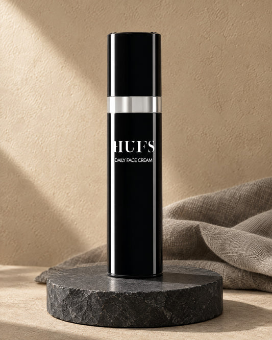HUFS Daily Face Cream 50 ml im schwarzen Airless-Spender mit Silberring auf Schiefer-Sockel