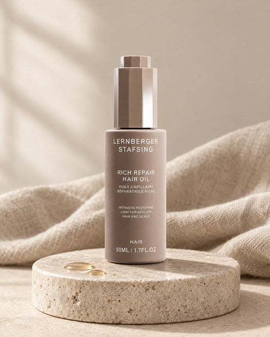 Lernberger Stafsing Rich Repair Haaröl 50 ml mit Pipettenkappe auf Travertin-Sockel mit Öltropfen