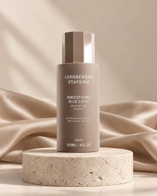 Lernberger Stafsing Smoothing Silk Coat 120 ml Anti-Frizz Serum auf Travertin-Sockel mit Seidentuch