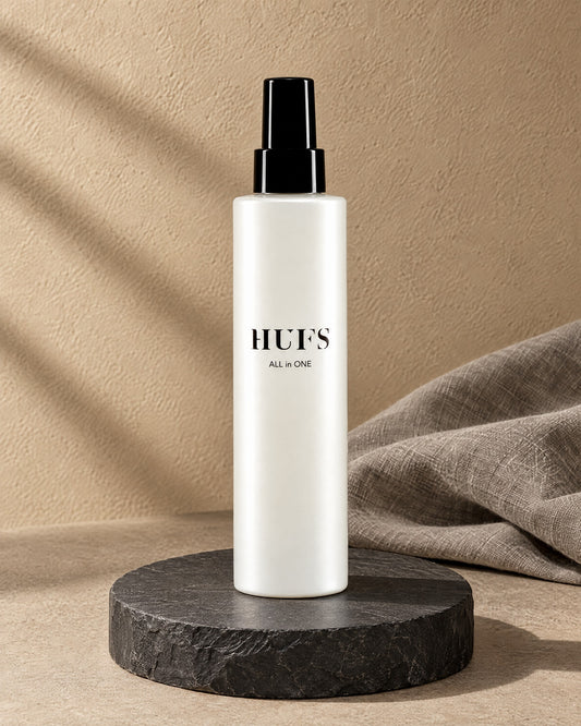 HUFS All in One Leave-in Spray 200 ml in perlweißer Sprühflasche auf dunklem Schiefer-Sockel