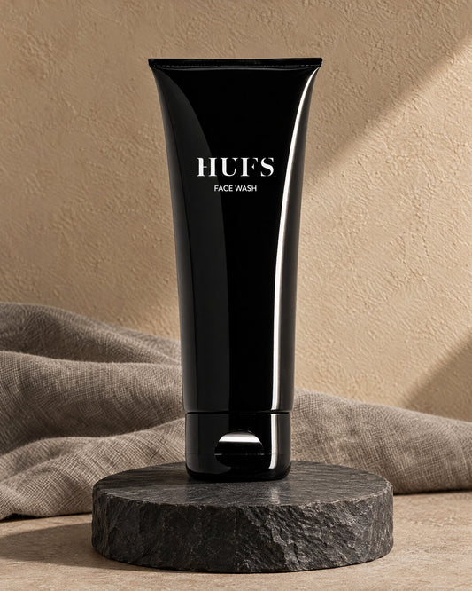 HUFS Face Wash 100 ml in glänzend schwarzer Tube auf dunklem Schiefer-Sockel