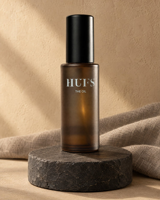 HUFS The Oil Haaröl 50 ml in mattierter Braunglasflasche mit schwarzer Kappe auf Schiefer-Sockel