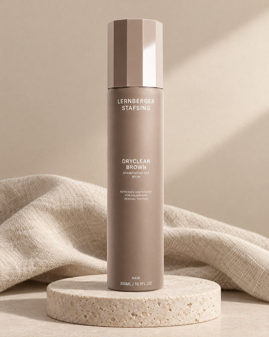 Lernberger Stafsing Dryclean Brown 300 ml, getöntes Trockenshampoo in Taupe auf Travertin-Sockel